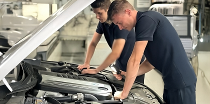 Zwei männlicher Mechatroniker schauen in einen Motorraum